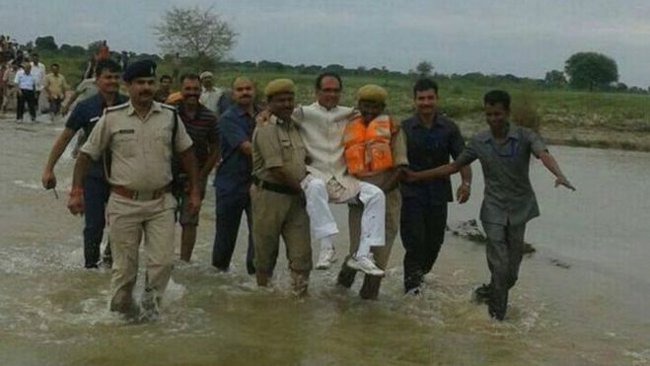 মন্ত্রী জনগনের বন্ধু-তাই কোলে চড়ে বন্যাদর্শন করলেন তিনি!